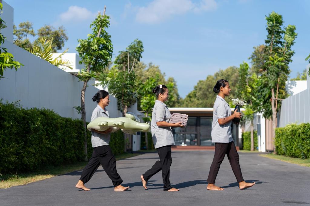Villa staff walking the grounds with fresh towels and pool float